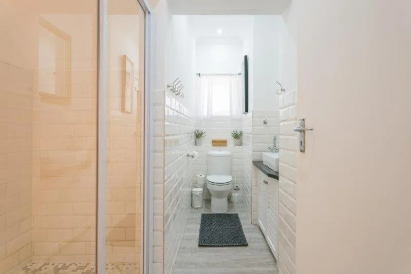 Modern bathroom with white subway tiles, toilet, vanity sink, and shower area