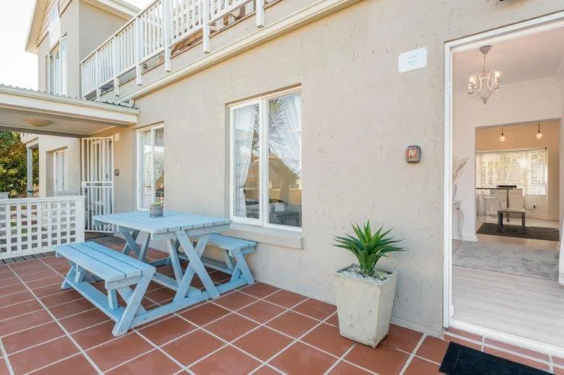 Blue picnic table on terracotta tiled patio with ocean views
