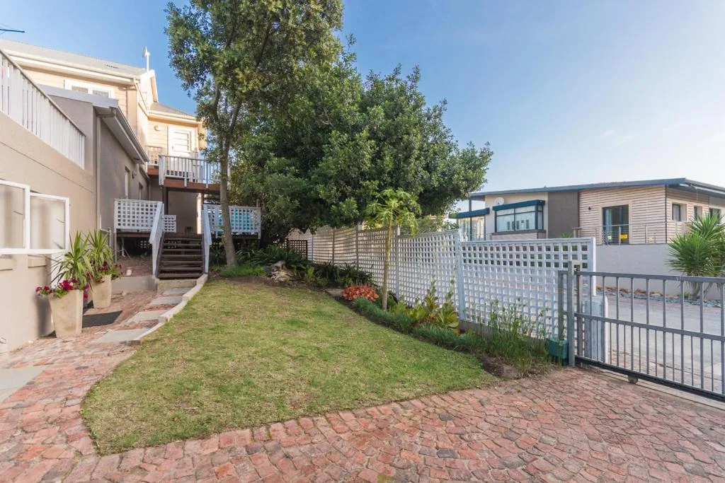 Garden Route property with brick courtyard, lush lawn, and modern buildings