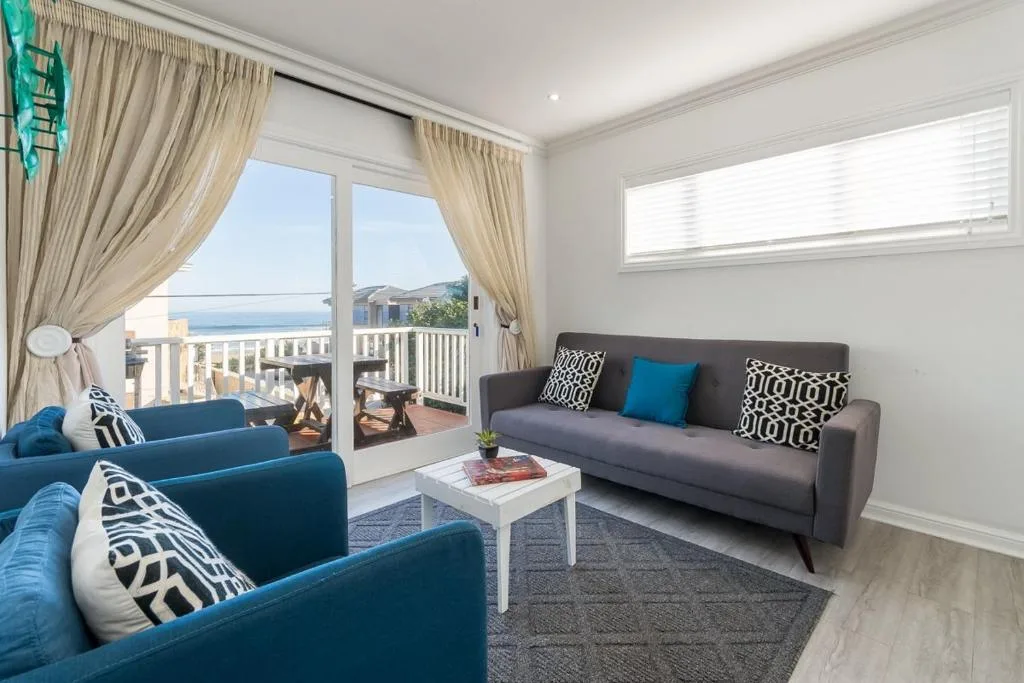 Bright lounge with blue armchairs, ocean view through glass doors and windows