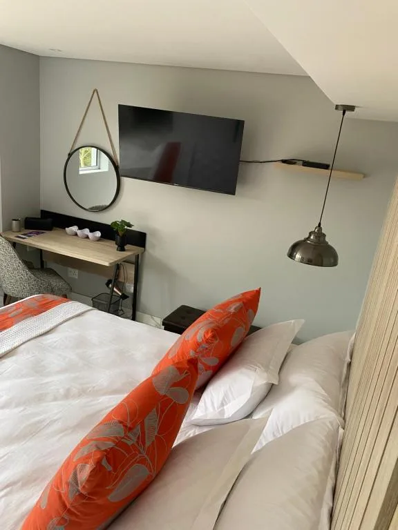 Modern bedroom with bed, wall-mounted TV, and contemporary decor