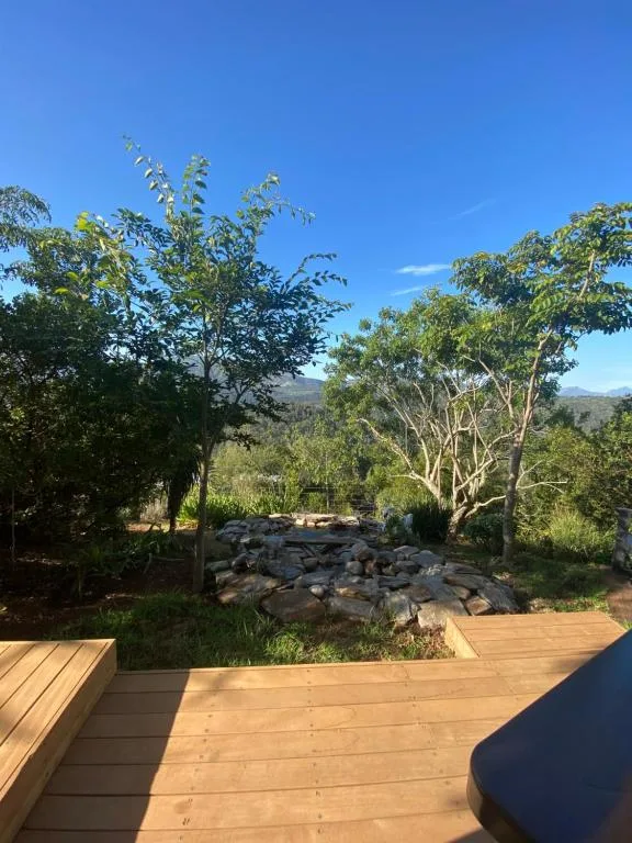 Wooden deck overlooking mountain landscape with native trees and garden