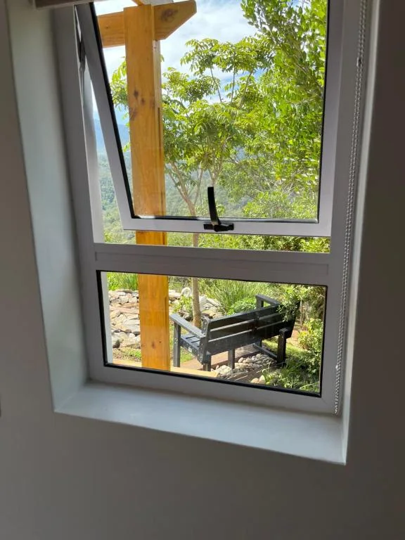 Garden views through open window with outdoor seating visible