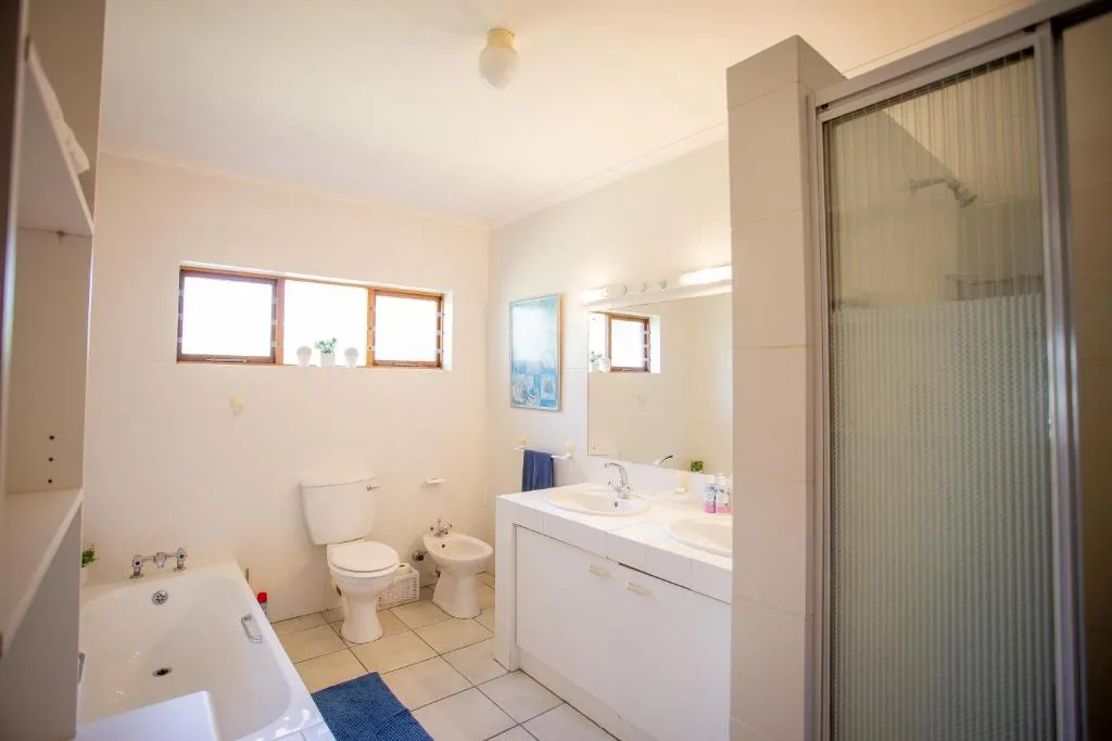 Bright bathroom with bathtub, toilet, bidet, vanity sink, and shower enclosure