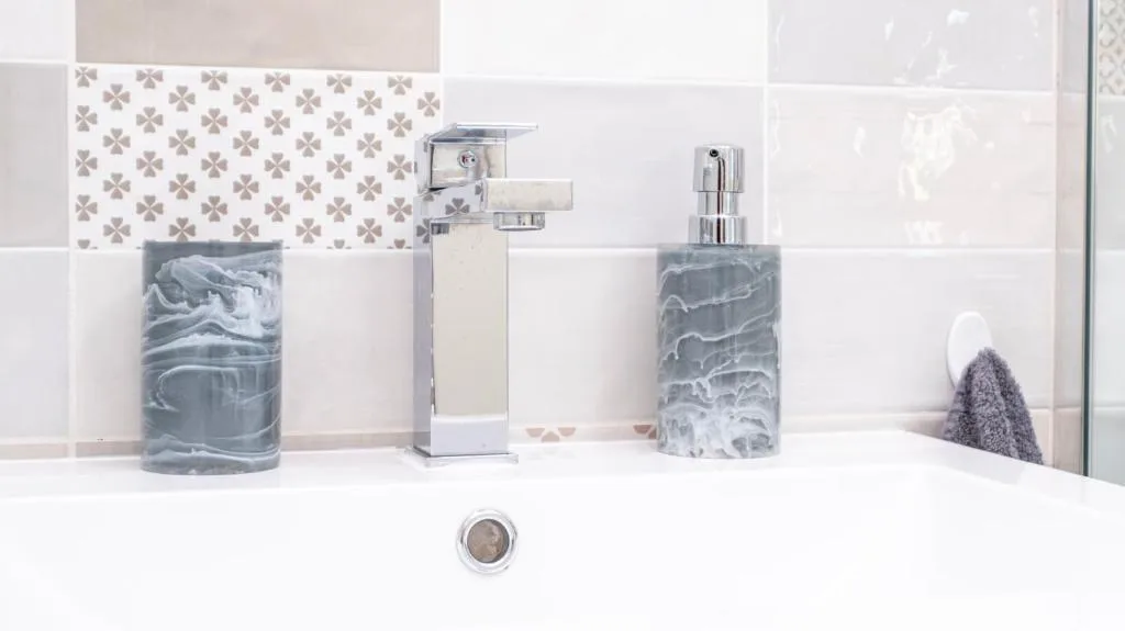 Modern bathroom vanity with geometric tile backsplash and chrome fixtures
