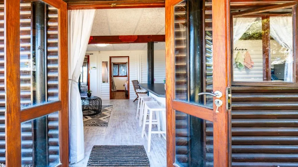 Wooden deck with louvre doors opening to interior seating area