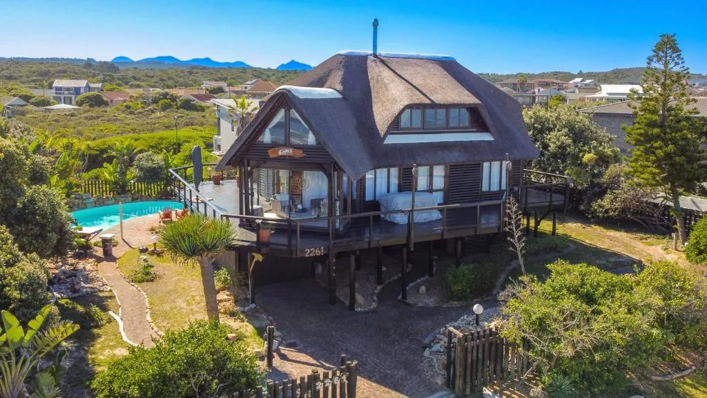 Thatched-roof house with pool overlooking Garden Route mountains and valley landscape