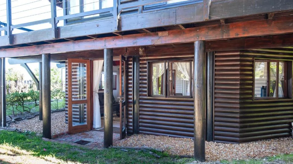 Timber-clad building entrance with corrugated metal siding and wooden deck