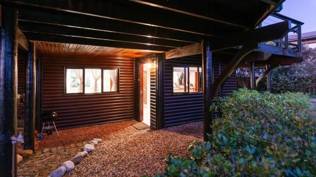 Modern cabin exterior with corrugated metal siding illuminated at dusk
