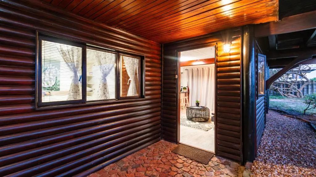 Modern corrugated metal cabin exterior with windows and entrance door at dusk