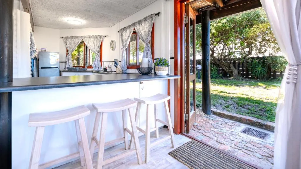 Modern kitchen with counter seating and garden view through open doors