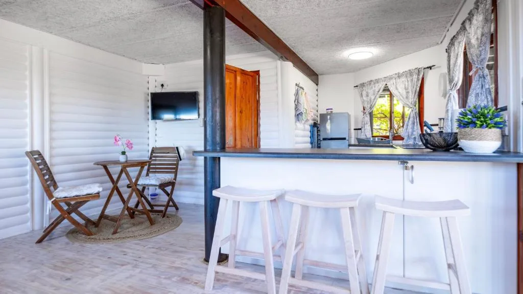 Open-plan kitchen with island counter and white bar stools, modern appliances