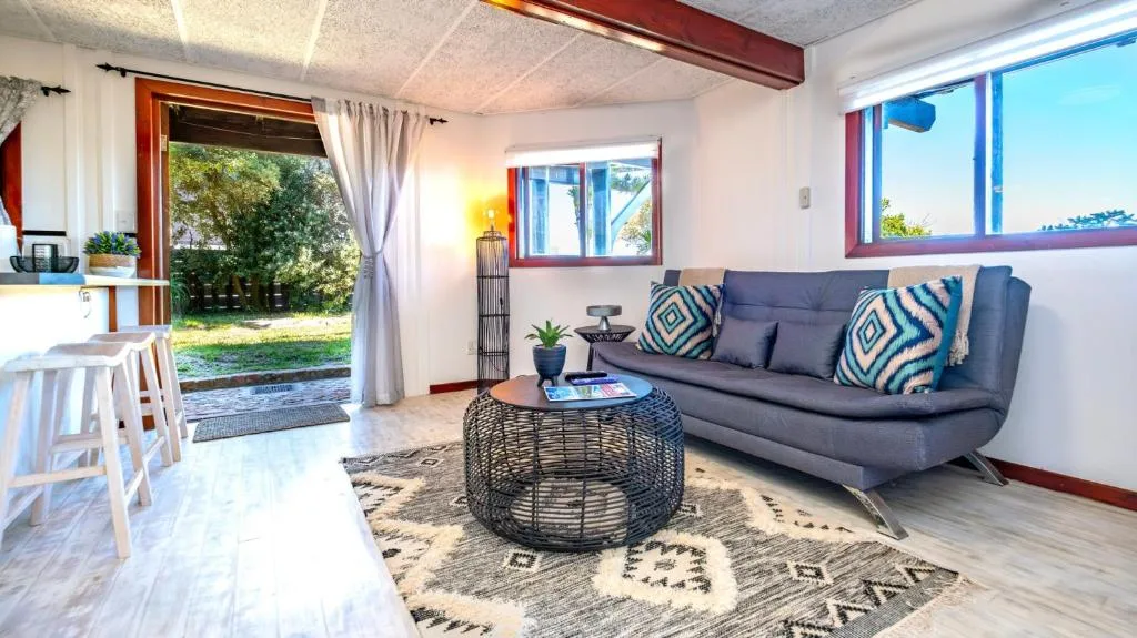 Modern living room with blue sofa, patterned cushions, and woven coffee table