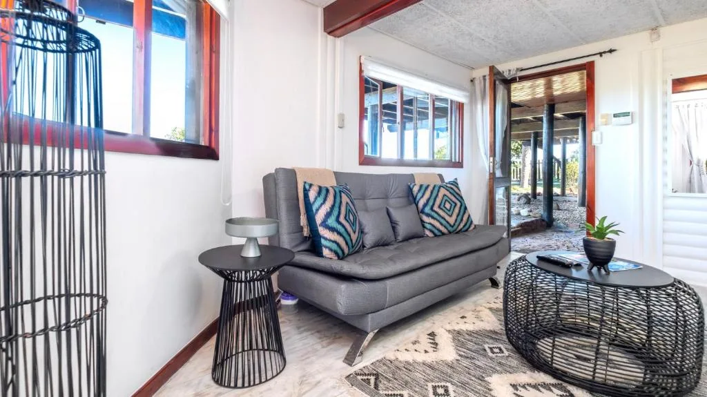 Modern lounge with gray sofa, patterned cushions, and contemporary side tables