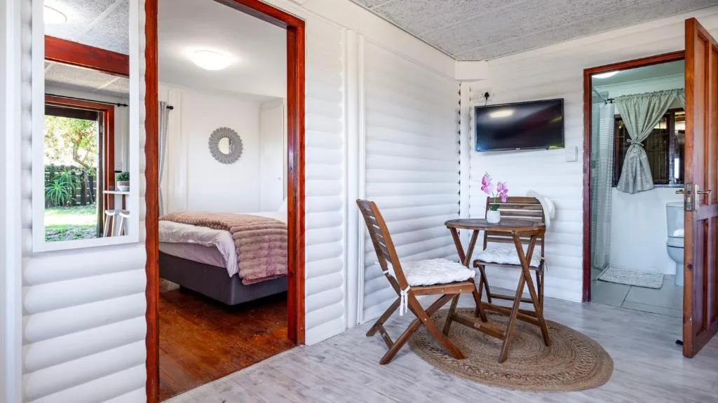 Open-plan lounge with desk, chair, and wall-mounted television entertainment