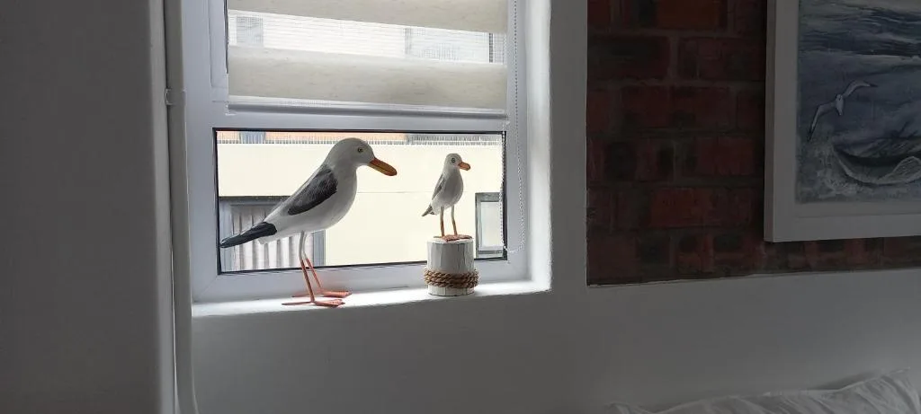 Window sill with seagull artwork and coastal-themed decorative ornaments
