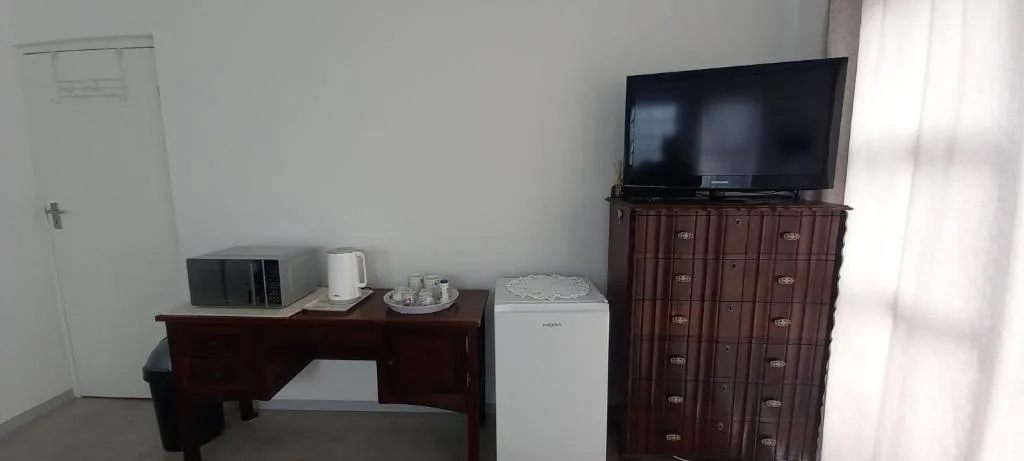 Bedroom amenities including microwave, kettle, mini-fridge, and flat-screen television