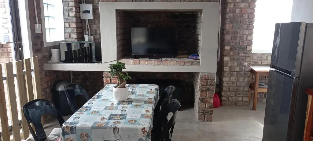 Living room with fireplace, flat-screen TV, and brick walls