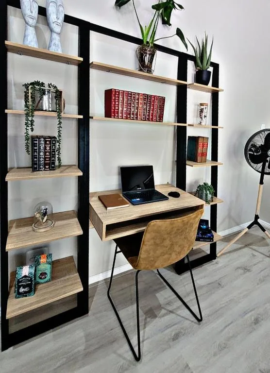 Modern home office desk setup with shelving unit and decorative accessories