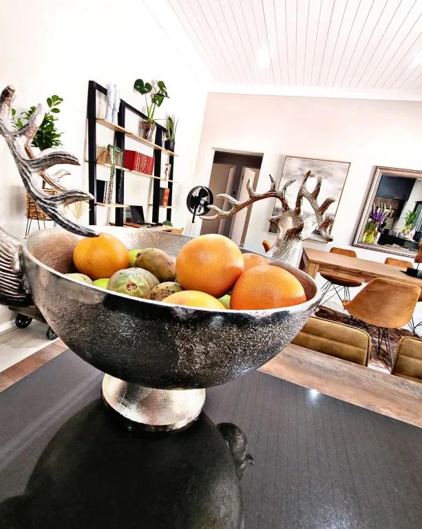 Decorative fruit bowl with fresh oranges and foliage in modern lounge