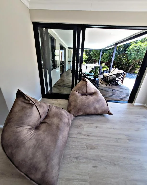 Modern lounge with bean bags opening to deck and pool area