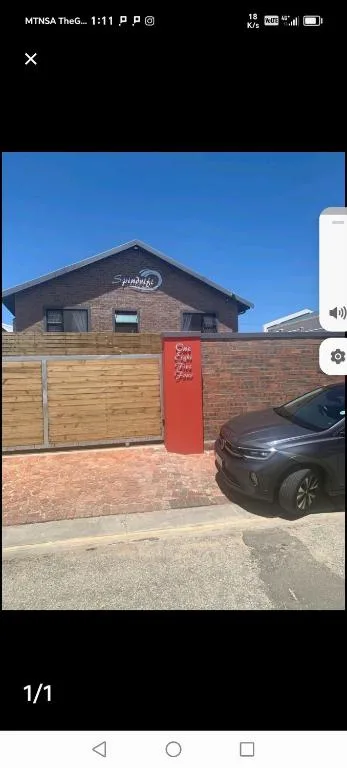 Modern brick house with wooden garage gates and parked car outside
