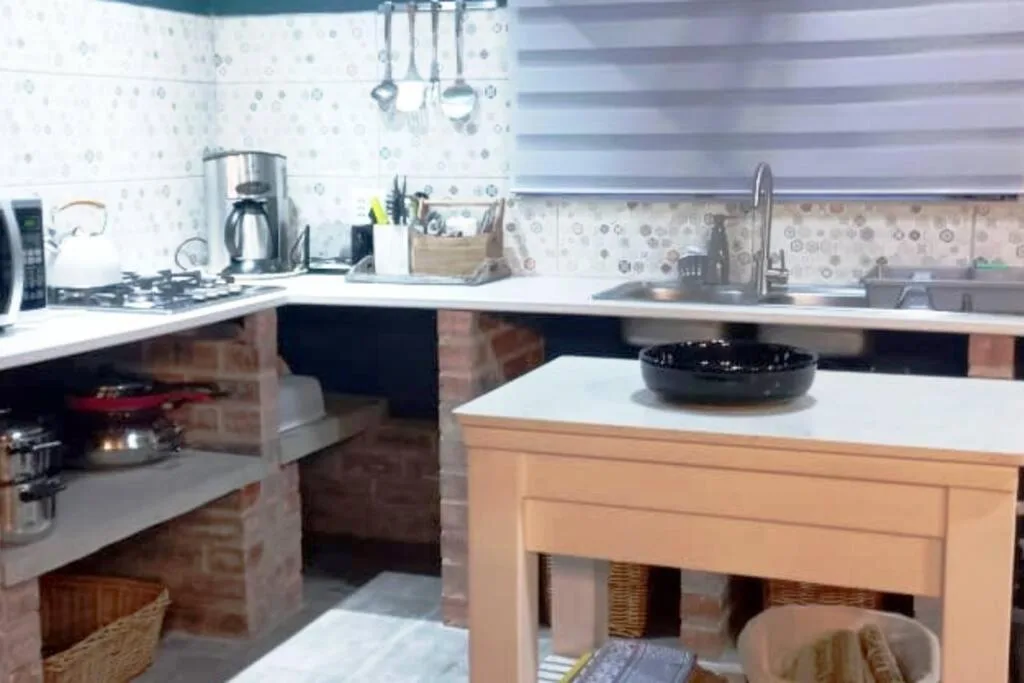 Modern kitchen with gas stove, white counters, and wooden island bench