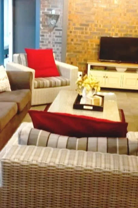 Modern living room with red accents, comfortable seating, and flat-screen television