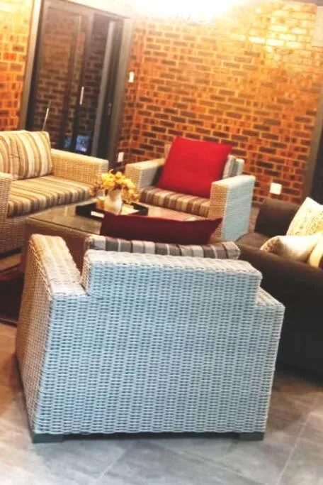 Spacious lounge with upholstered seating and exposed brick walls