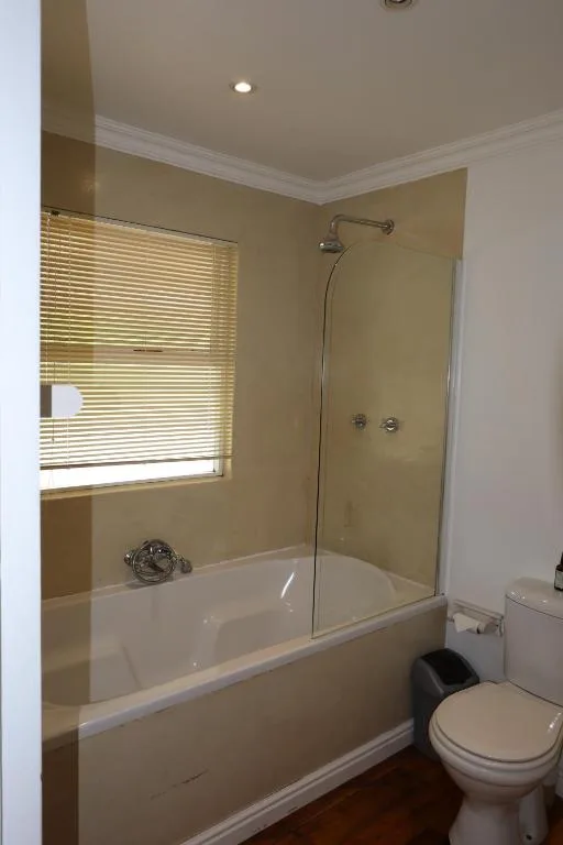 Bathroom with bathtub, glass shower enclosure, and toilet