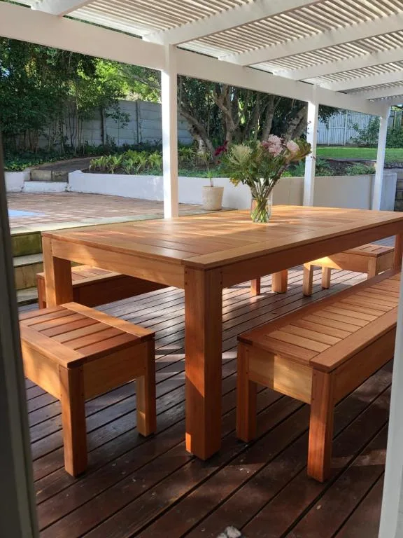 Wooden dining table and benches on covered patio deck
