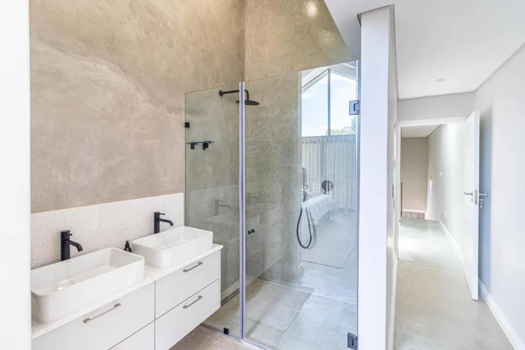 Modern bathroom with dual vanity sinks and walk-in shower enclosure