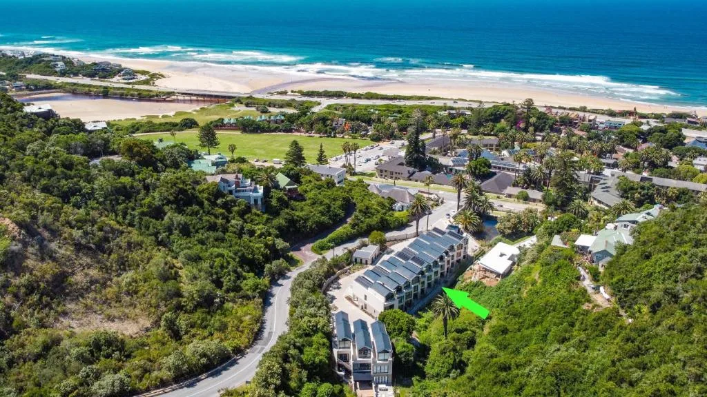 Aerial view of beachfront property with ocean, beach, lagoon, and town landscape