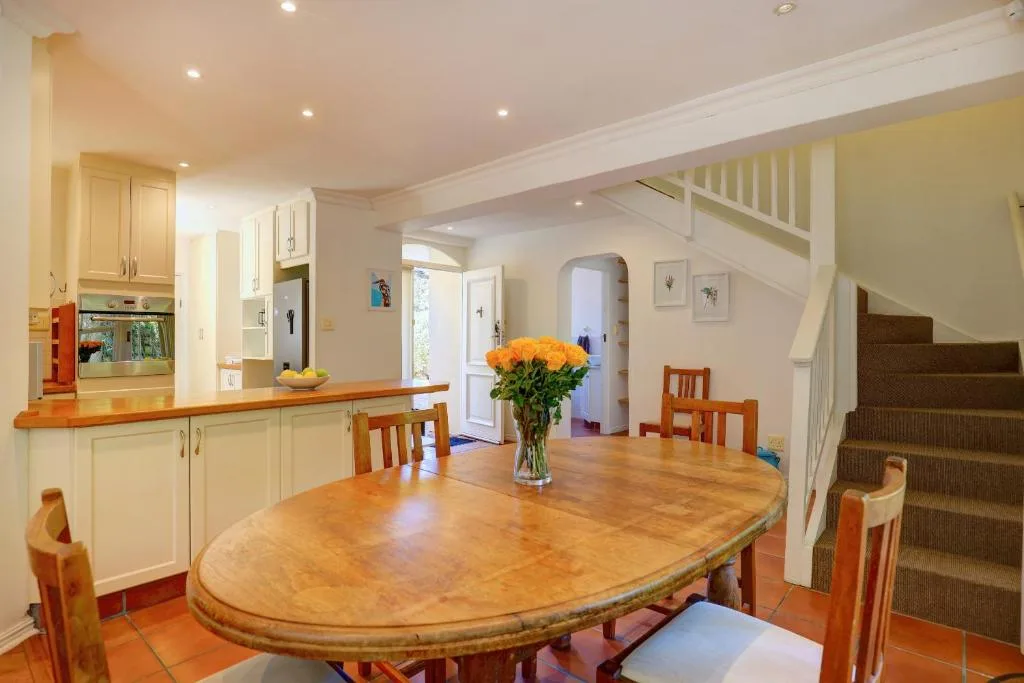 Spacious dining area with wooden table and kitchen beyond
