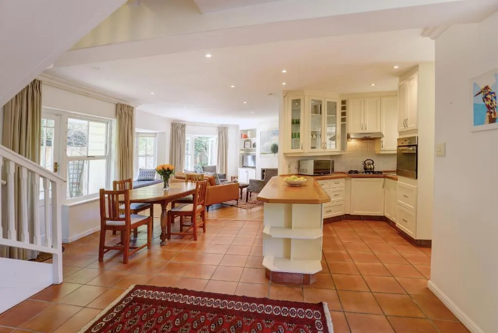 Open-plan kitchen with cream cabinetry, island counter, and terracotta floors