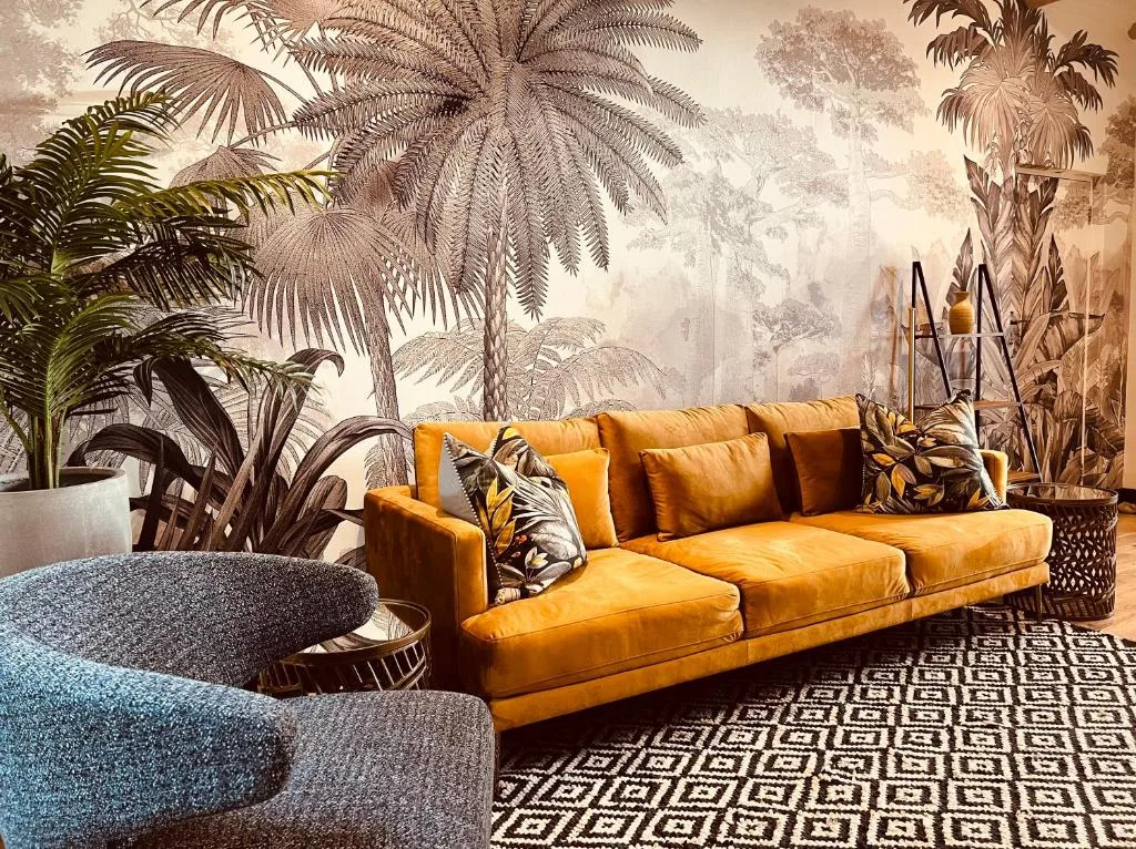 Modern lounge with golden leather sofa and botanical wall mural
