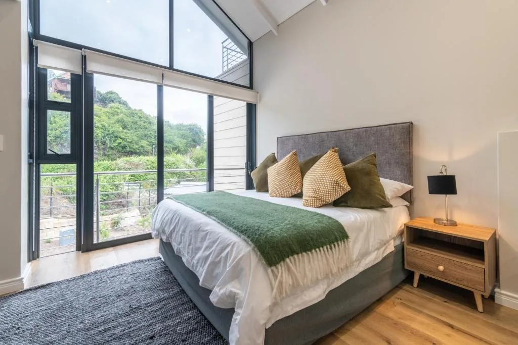 Spacious bedroom with large bed, mountain views through floor-to-ceiling windows