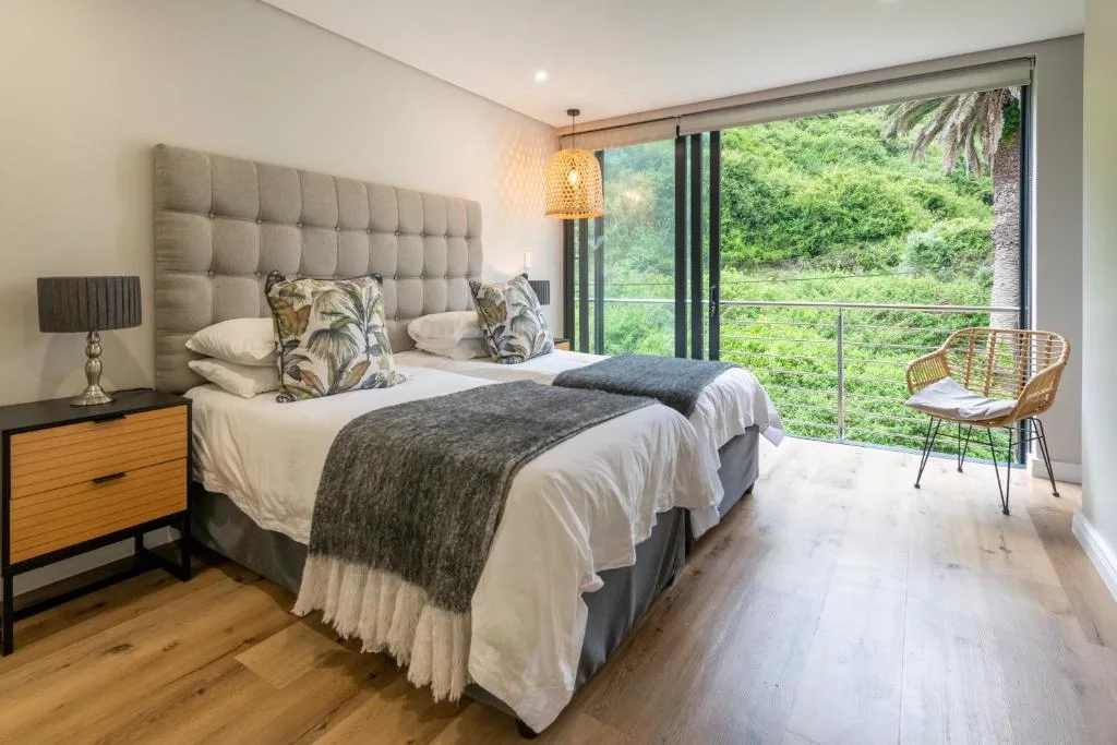Modern bedroom with twin beds, garden views through sliding glass doors