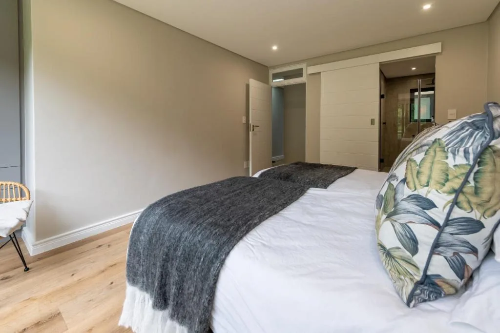 Spacious bedroom with double bed, wooden flooring, and ensuite bathroom access