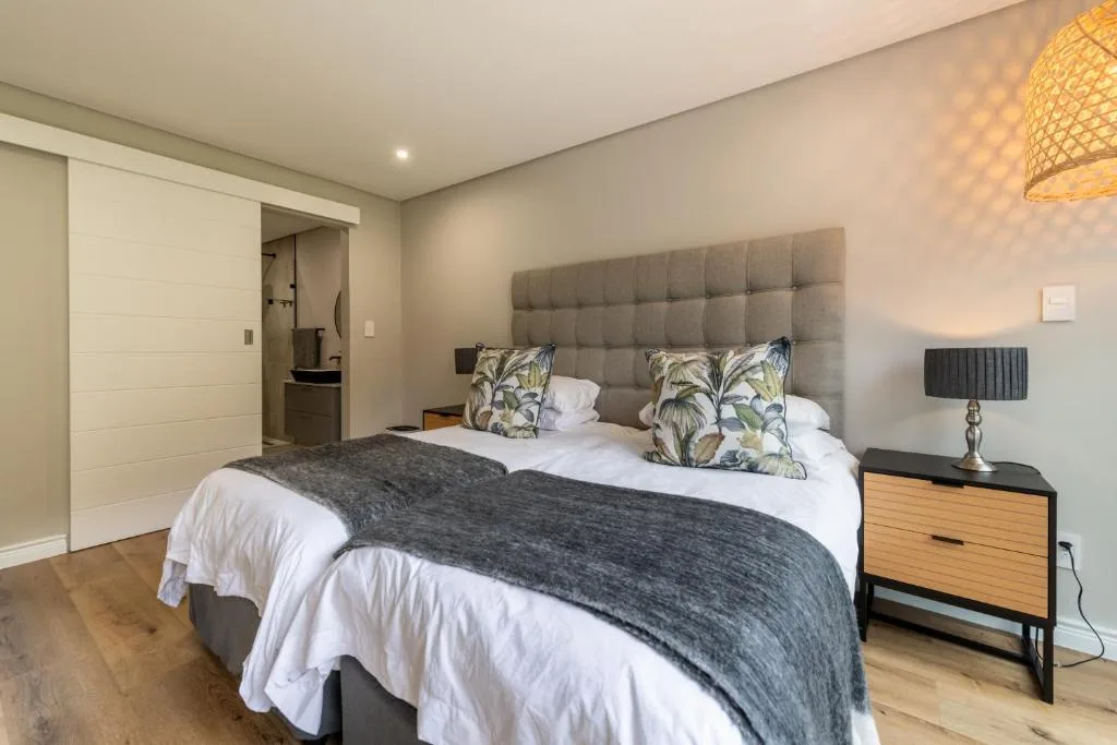 Spacious bedroom with queen bed, gray headboard, and modern furnishings