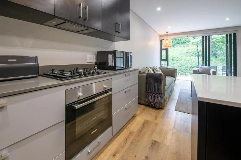 Modern kitchen with gas cooktop, stainless steel appliances, white cabinetry