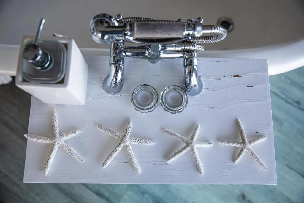 Chrome faucet and taps with starfish decorative accents on white shelf