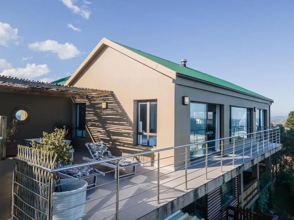 Modern deck with metal railings and lounge chairs overlooking landscape
