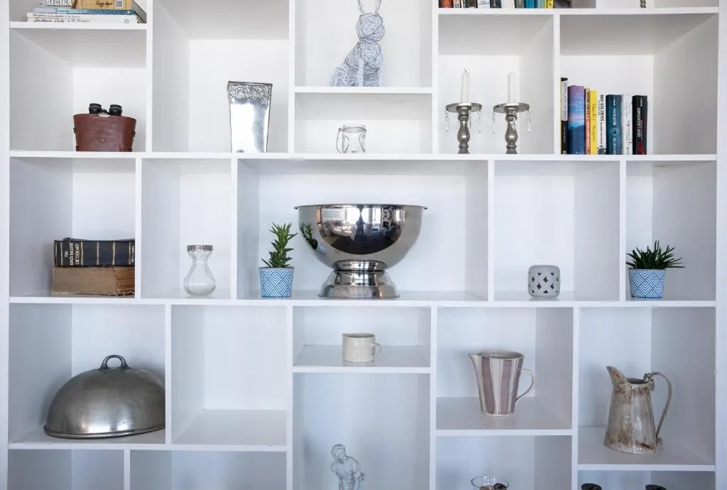 White shelving unit displaying decorative items, books, and home accessories