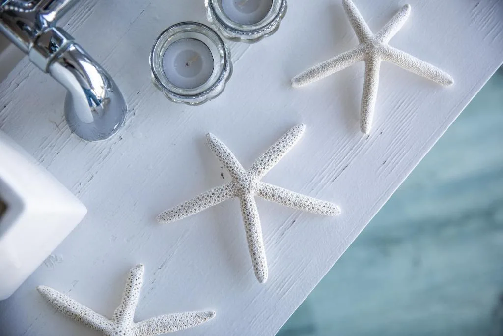 White starfish and candles arranged on coastal-themed wooden table