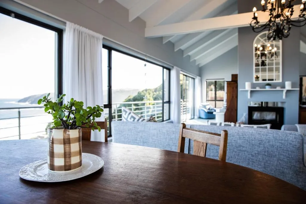 Dining table with mountain and water views through large windows