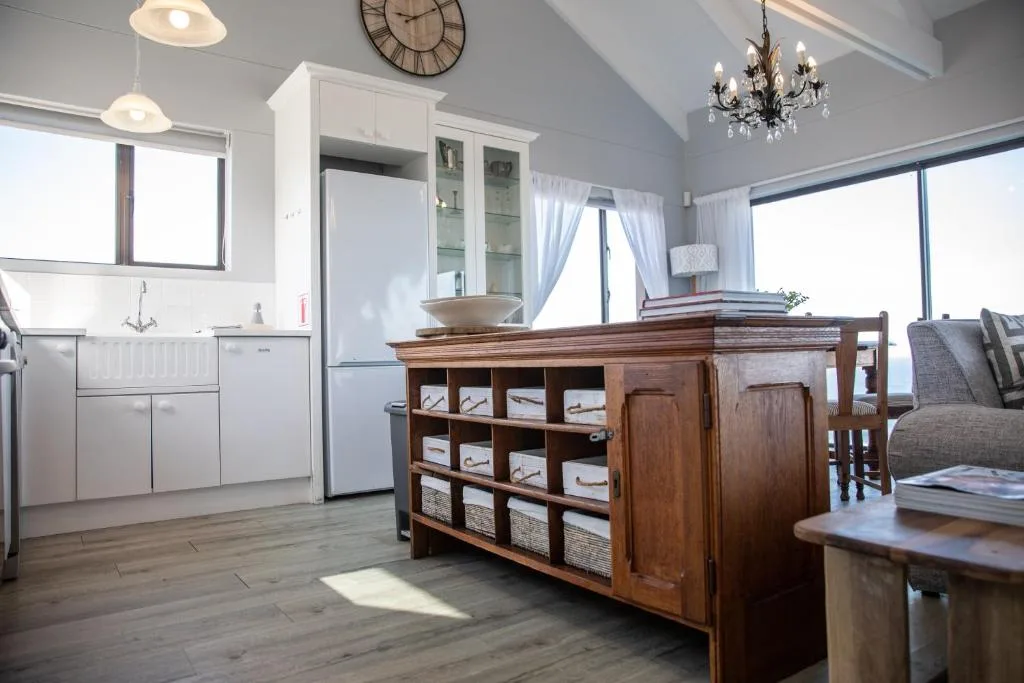 Modern kitchen with white cabinetry, stainless appliances, and wooden island