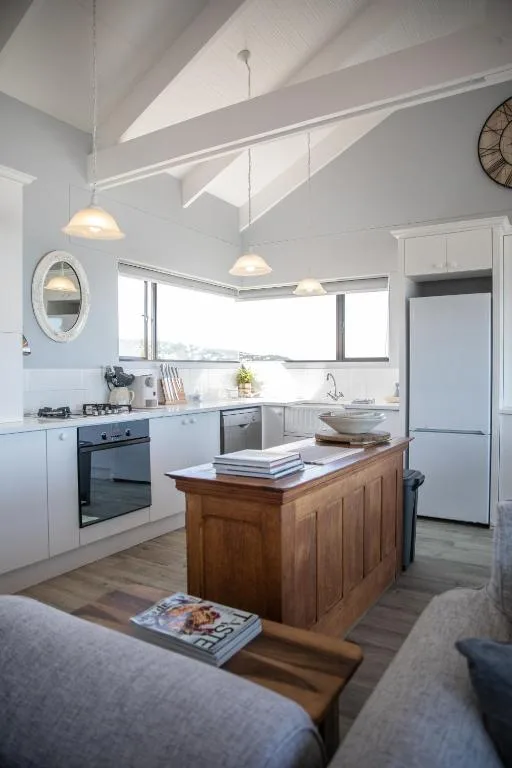Modern kitchen with white cabinetry, wooden island, and pendant lighting