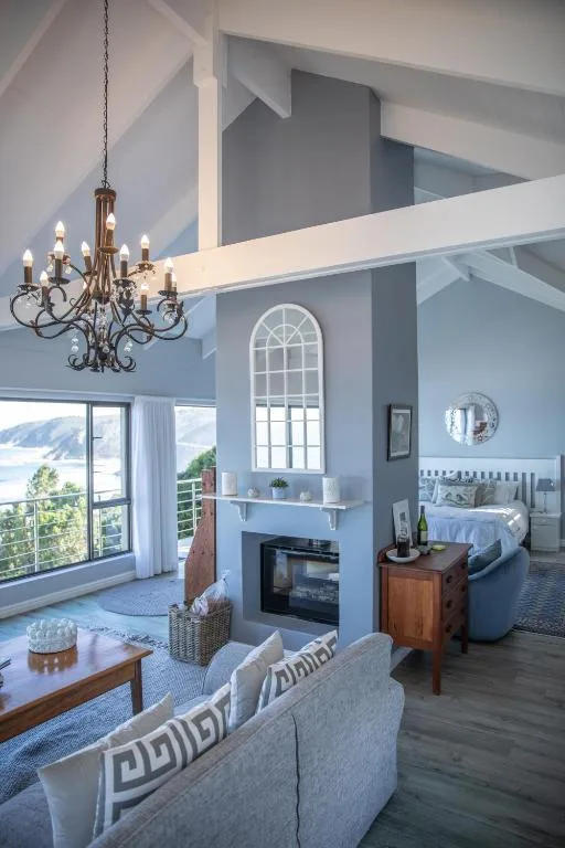 Modern loft lounge with fireplace, chandelier, and mountain views