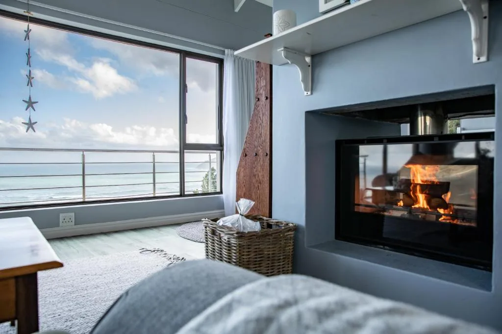 Modern lounge with fireplace, ocean view, and coastal decor